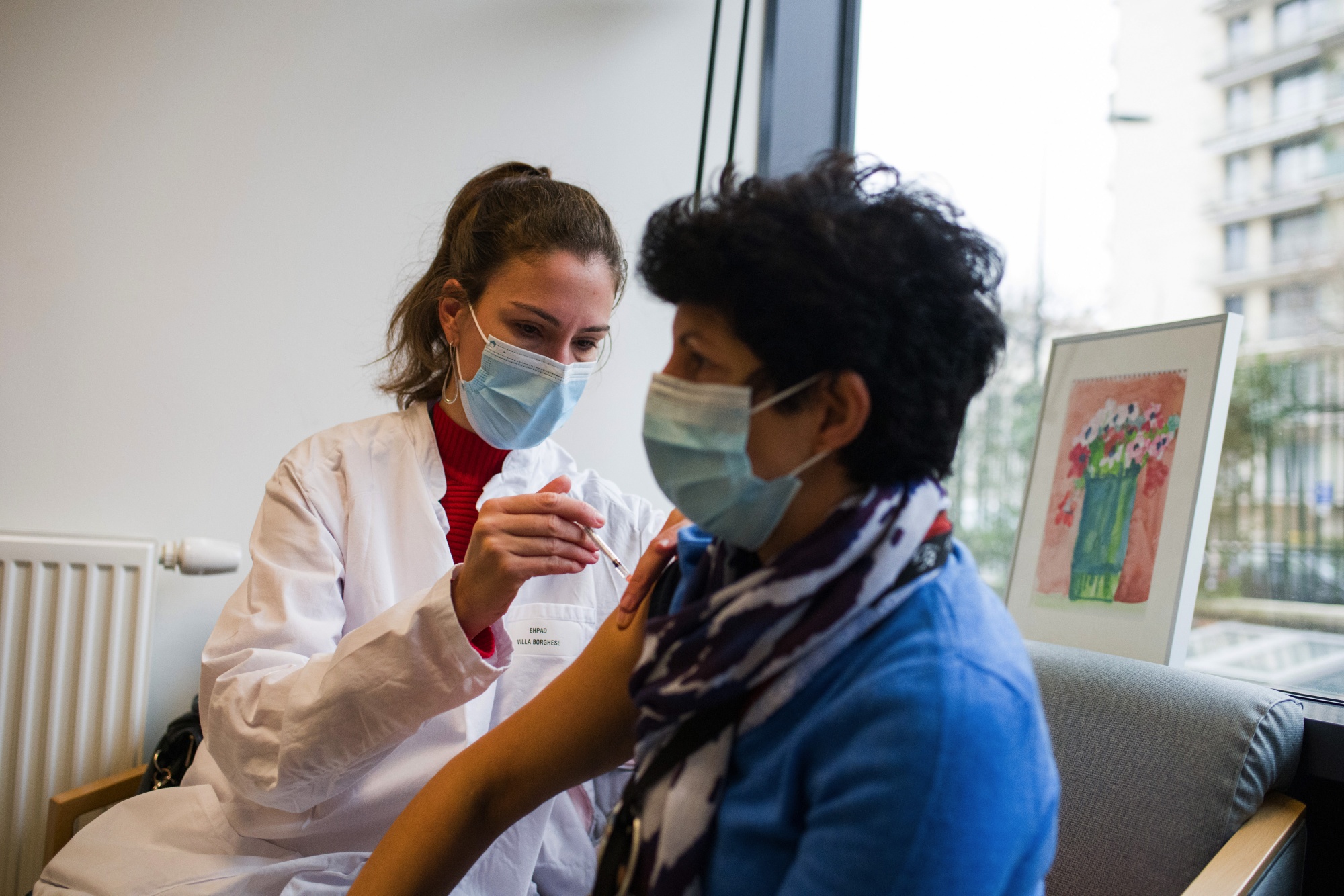 A healthcare worker receives a dose of the Pfizer-BioNTech Covid-19 vaccine at a care home in Paris.