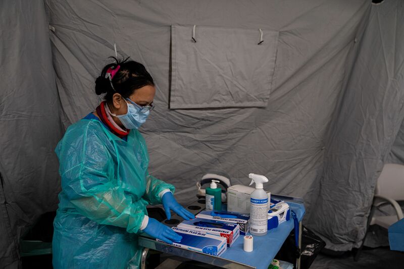 A medical worker wearing protective overalls checks supplies inside the pre-triage tent at the emergency room of the Mauriziano Hospital in Turin.