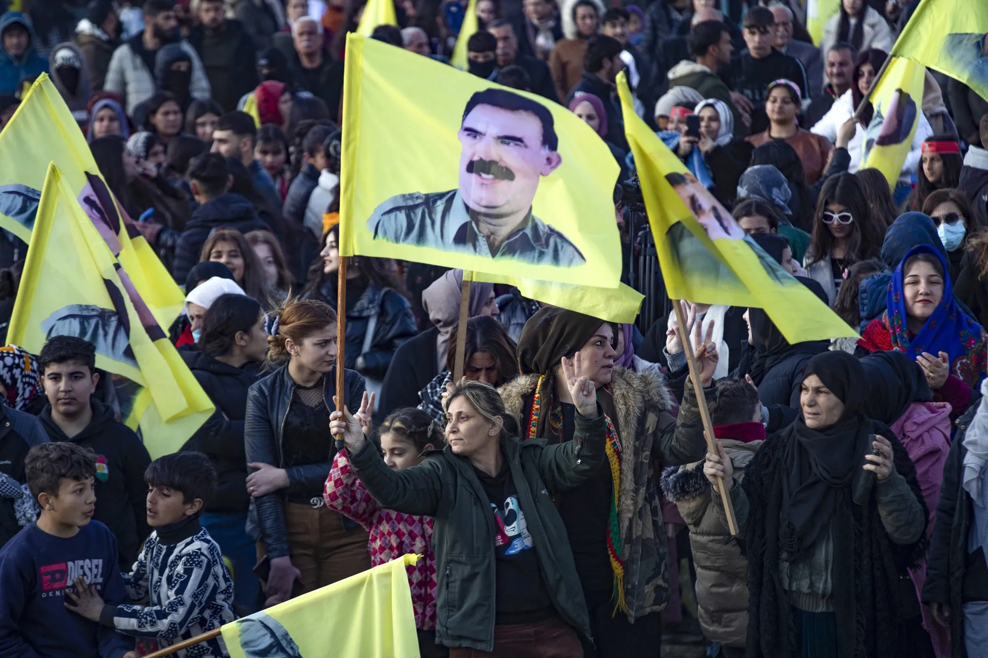 A Syrian Kurdish woman waves a flag bearing a picture of Abdullah Ocalan, as people gather in the Kurdish-majority city of Qamishli in northeastern Syria, on Feb.&nbsp;27.
