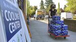 A volunteer helps set up snacks at a cooling center established to help vulnerable residents ride out a dangerous heat wave on Aug. 11, 2021. The historic heat wave, which toppled all-time temperature records, killed more than 200 people in Oregon and Washington. Now, lawmakers in the Pacific Northwest are eyeing several emergency heat relief bills aimed at helping vulnerable populations. The proposed measures would provide millions in funding for cooling systems and weather shelters during future extreme weather events. (AP Photo/Gillian Flaccus, File)