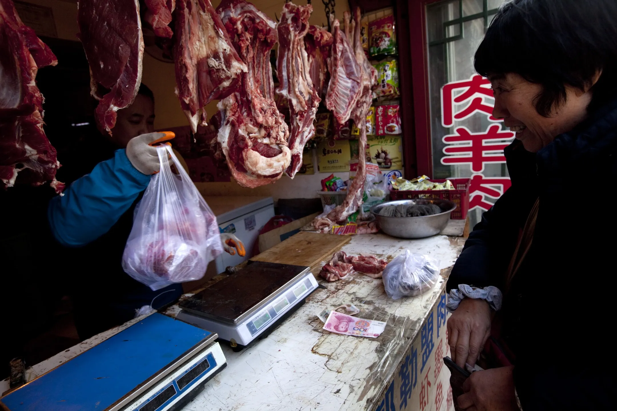 A customer purchases beef from a butcher in Beijing.