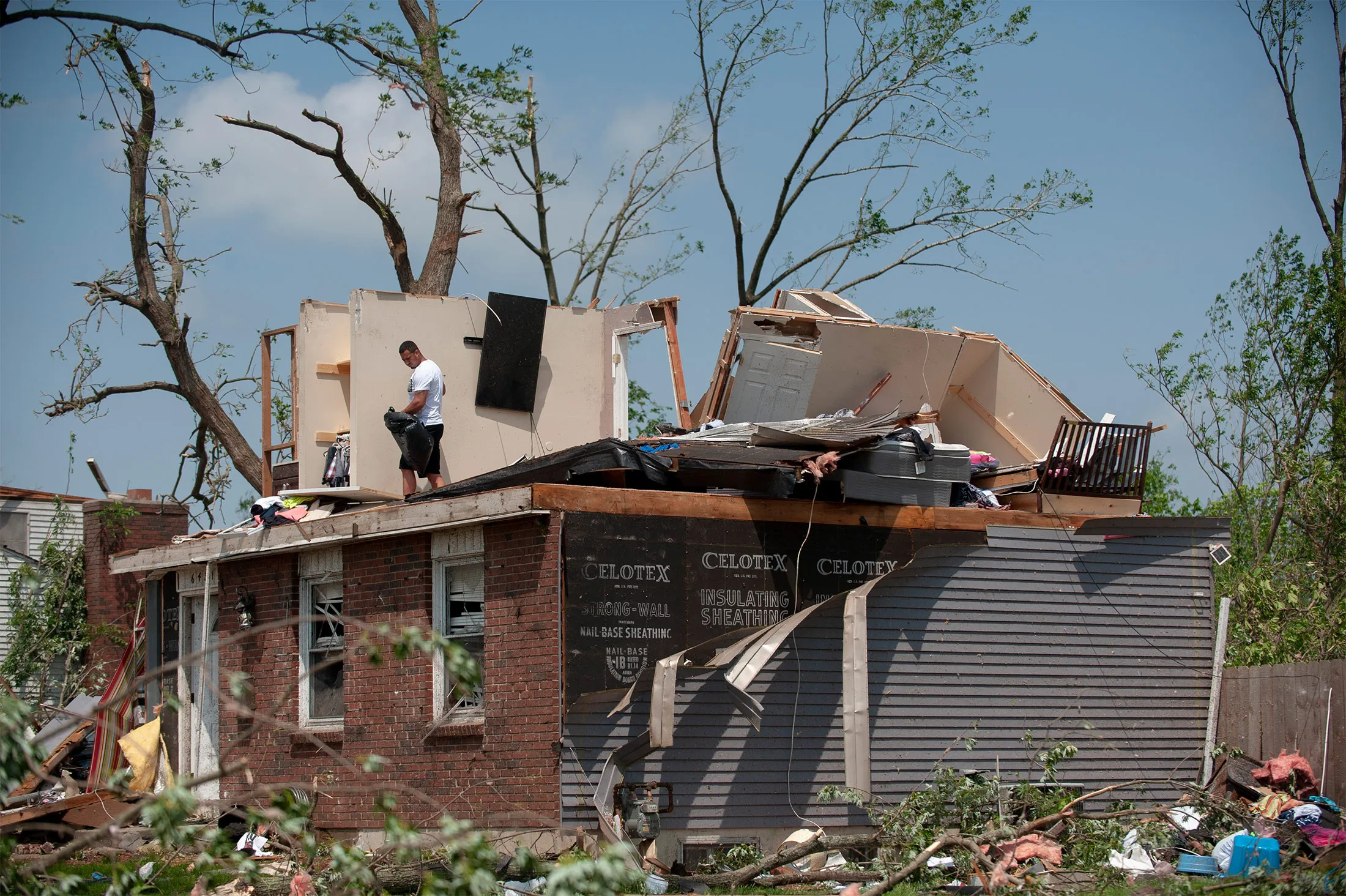 A resident&nbsp;picks up debris the morning after a tornado touched down&nbsp;in Trotwood, Ohio, on&nbsp;May 28.