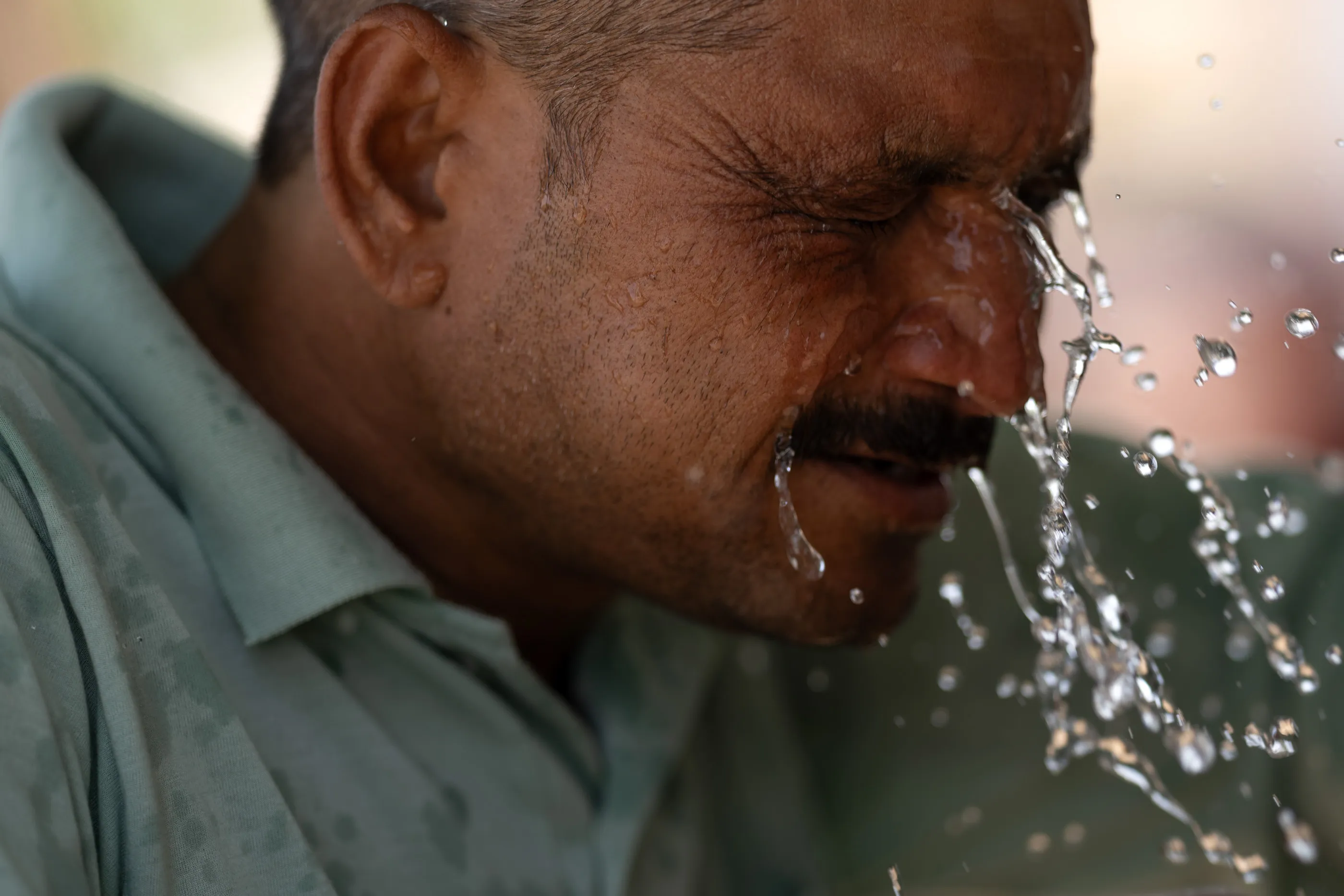 Nemi Chand, a 30-year-old laborer, splashes water on his face at a farm in&nbsp;Rajasthan state, India, on&nbsp;May 23.