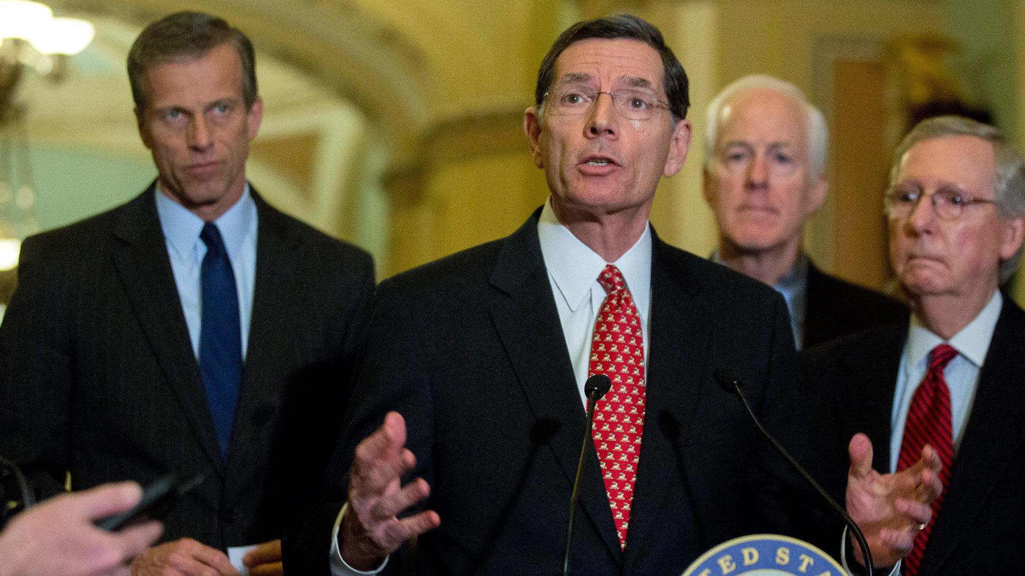 Senator John Barrasso, a Republican from Wyoming, center, speaks during a news conference following a Senate luncheon at the U.S. Capitol with John Thune, a Republican from South Dakota, from left, Barrasso, John Thune, a Republican from South Dakota, and Senate Majority Leader Mitch McConnell, a Republican from Kentucky, in Washington, D.C., U.S., on Tuesday, Feb. 24, 2015. 
