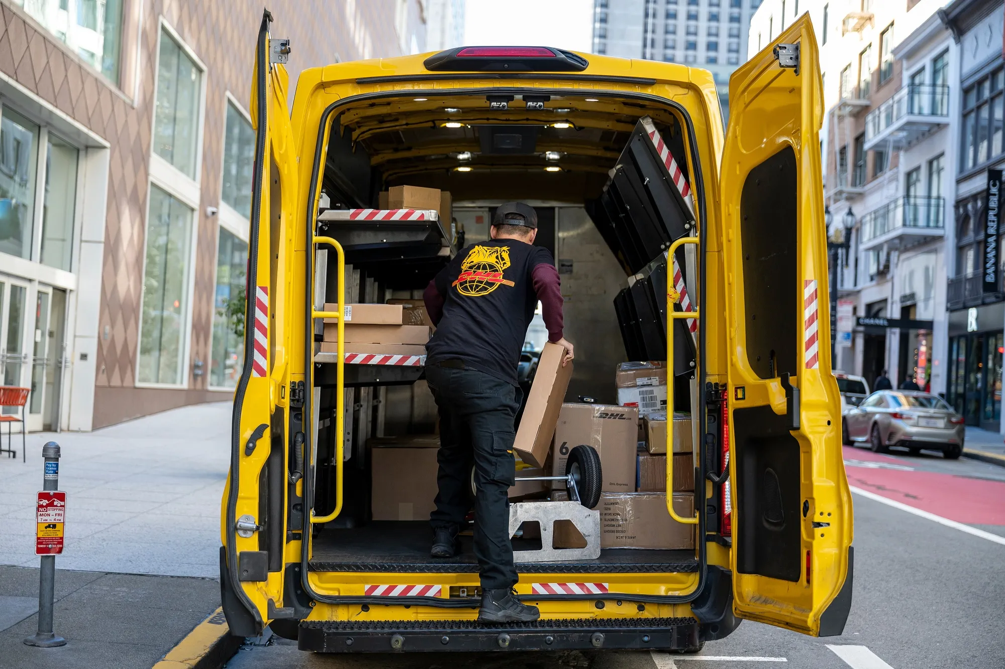 A worker unloads packages from a van in San Francisco.