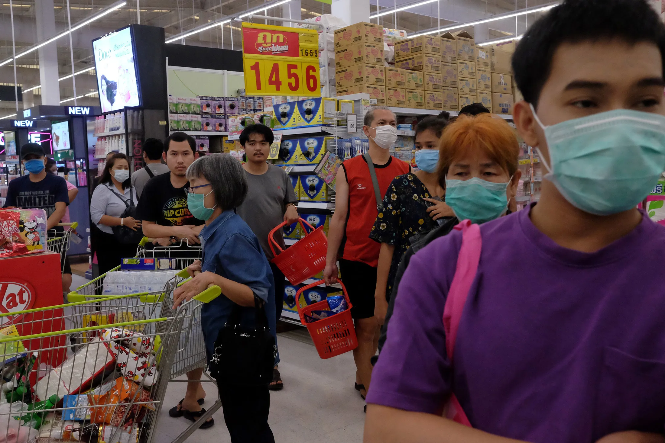 Shoppers wait in line to pay for groceries at a supermarket in Bangkok on March 15.
