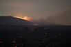 A new fire, being dubbed the Pine Fire, is seen in the distance as a landscape of embers burns in the wake of the North Fire, which caused people to abandon their vehicles and flee as flames jumped the 215 freeway in the early morning hours of July 18, 2015 near Victorville, California.
