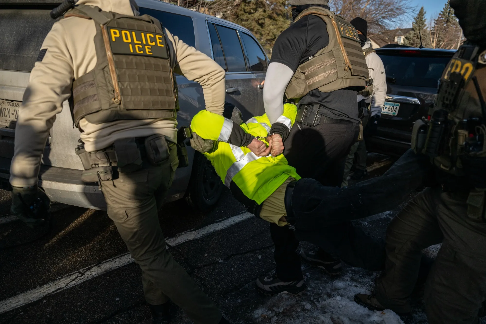 Federal law enforcement agents detain a demonstrator during a raid in Minneapolis on Jan. 13.