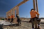 Contractors raise a framed wall on a house under construction in Folsom, California.