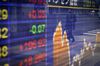 A pedestrian wearing a protective mask is reflected in an electronic stock board outside a securities firm in Tokyo, Japan, on Monday, Jan. 4, 2021. Asian stocks climbed to a new record, as technology shares remained strong in the first session of 2021.