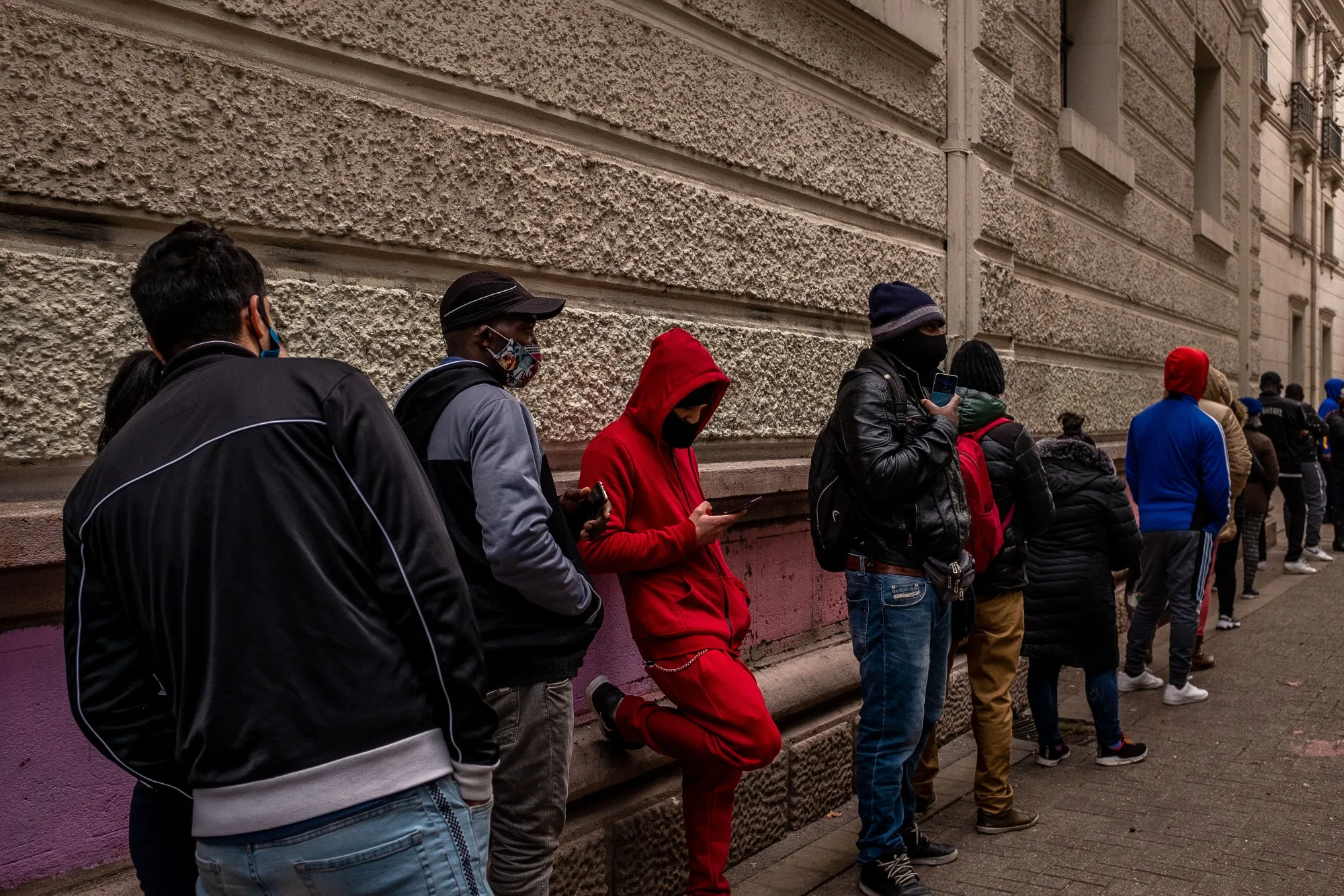People wearing protective masks stand in line outside of a pension fund managing office in Santiago, Chile, in July 2020.&nbsp;