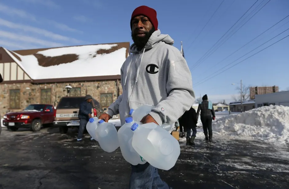 Lemott Thomas carries free water being distributed at the Lincoln Park United Methodist Church in Flint, Michigan, in February 2015. 
