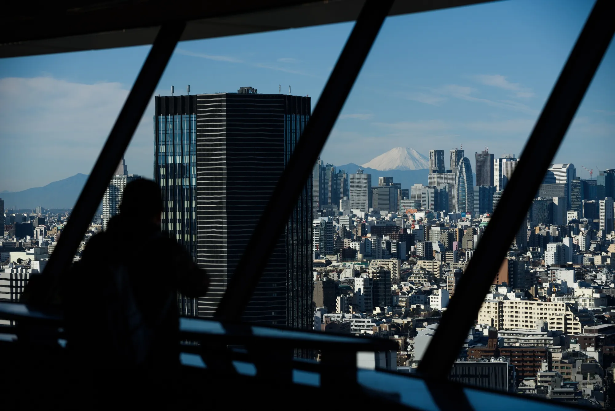 Mount Fuji stands beyond the buildings of Tokyo, Japan.