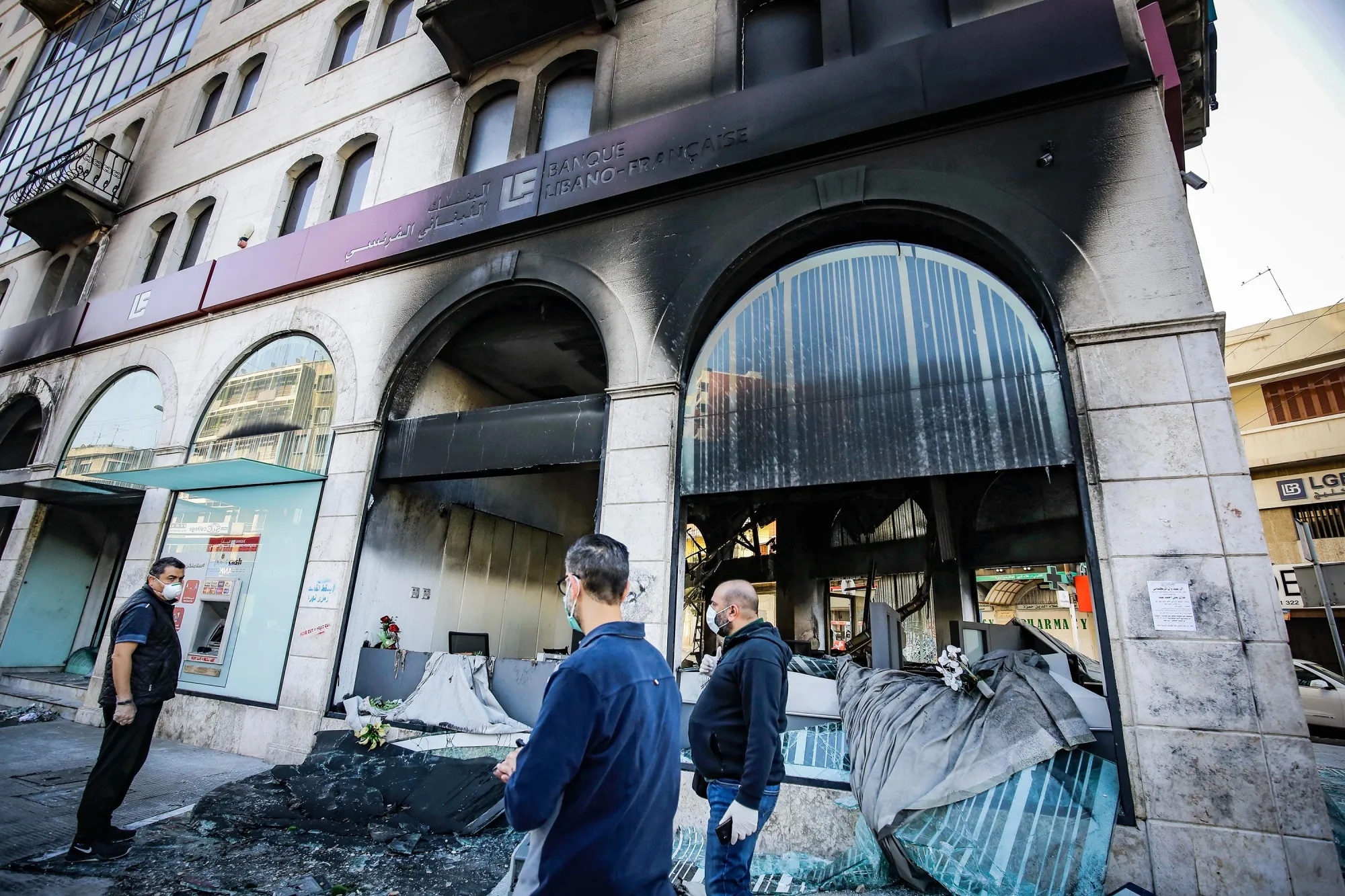 People inspect a bank set ablaze overnight by&nbsp;protesters, in&nbsp;Tripoli on April 28.