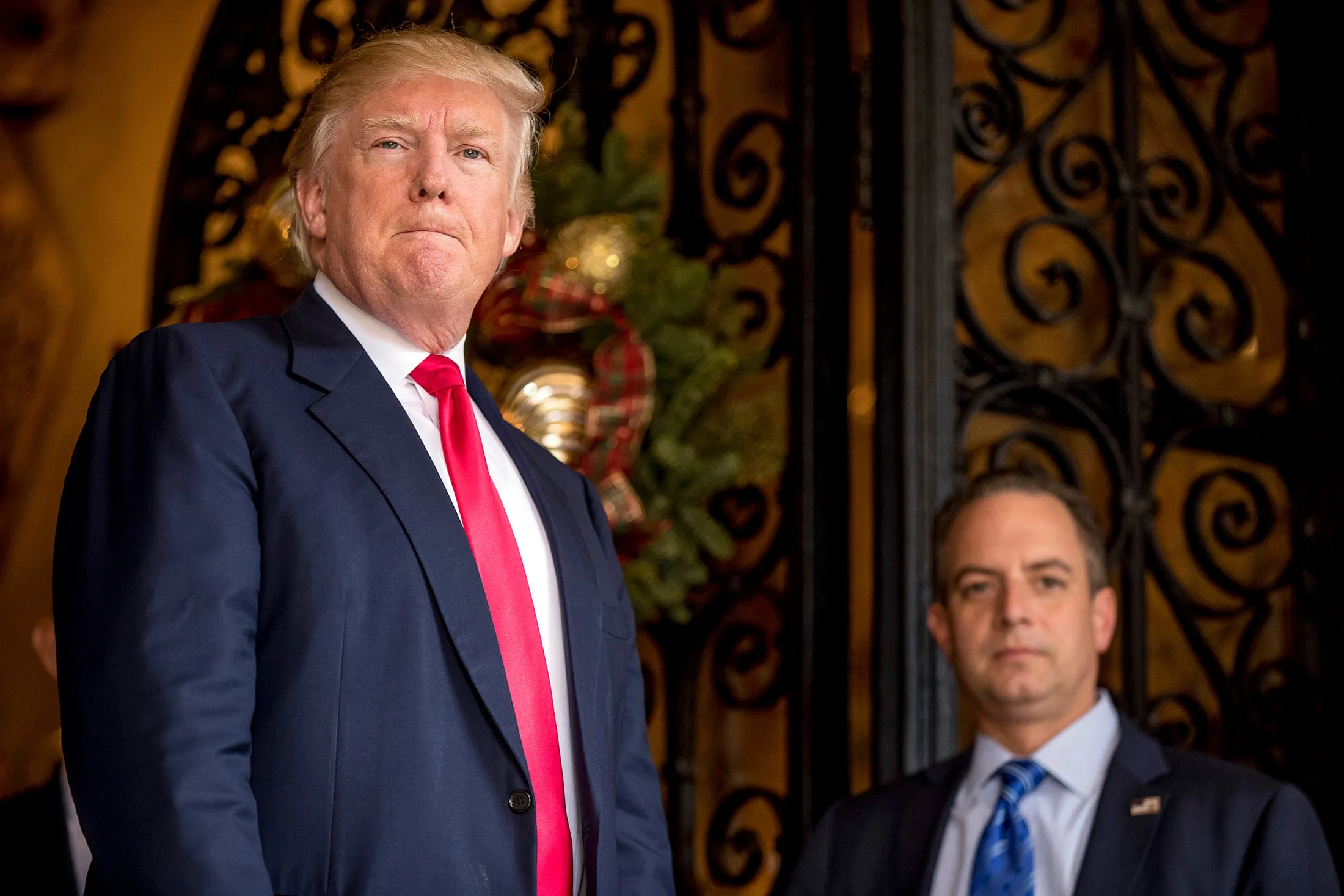 President-elect Donald Trump, left, accompanied by Trump Chief of Staff Reince Priebus, right, pauses as he takes a question from a member of the media at Mar-a-Lago, in Palm Beach, Fla., on Dec. 21, 2016.
