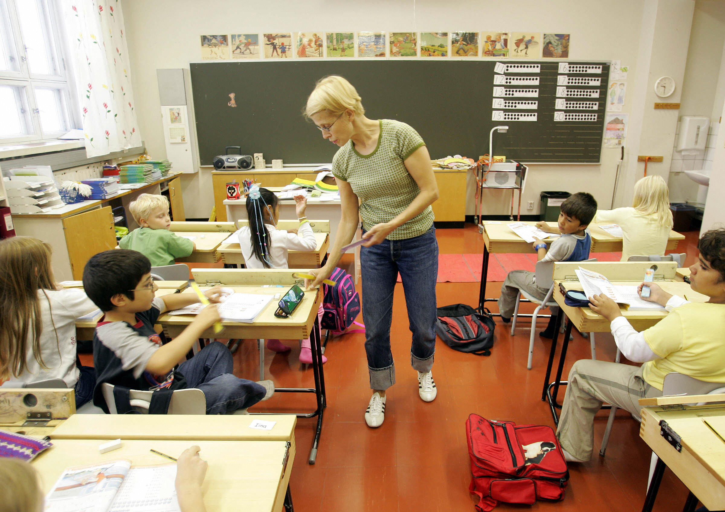 A teacher giving rulers to children&nbsp;in Finland. The Nordic country’s education system is a prime reason it scores at the top of the “Years of Good Life (YoGL)” economic index