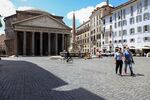 Pedestrians, wearing protective face masks, walk in view of the Pantheon in Rome on May 19.