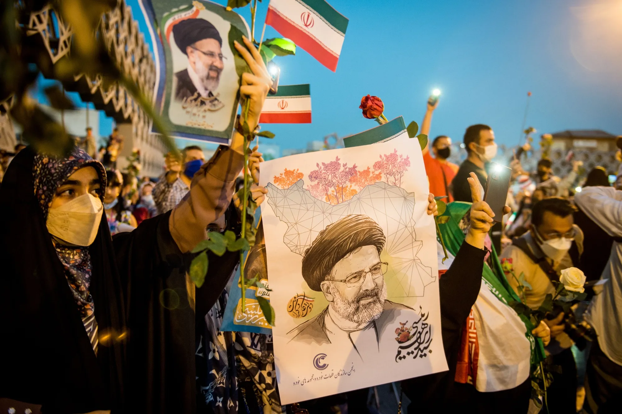 Supporters hold photographs of Ebrahim Raisi as they celebrate his presidential election win&nbsp;in Tehran on&nbsp;June 19.