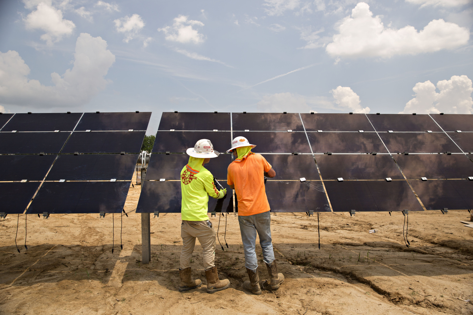 Workers secure solar panels on a solar farm in Milligan, Tennessee.