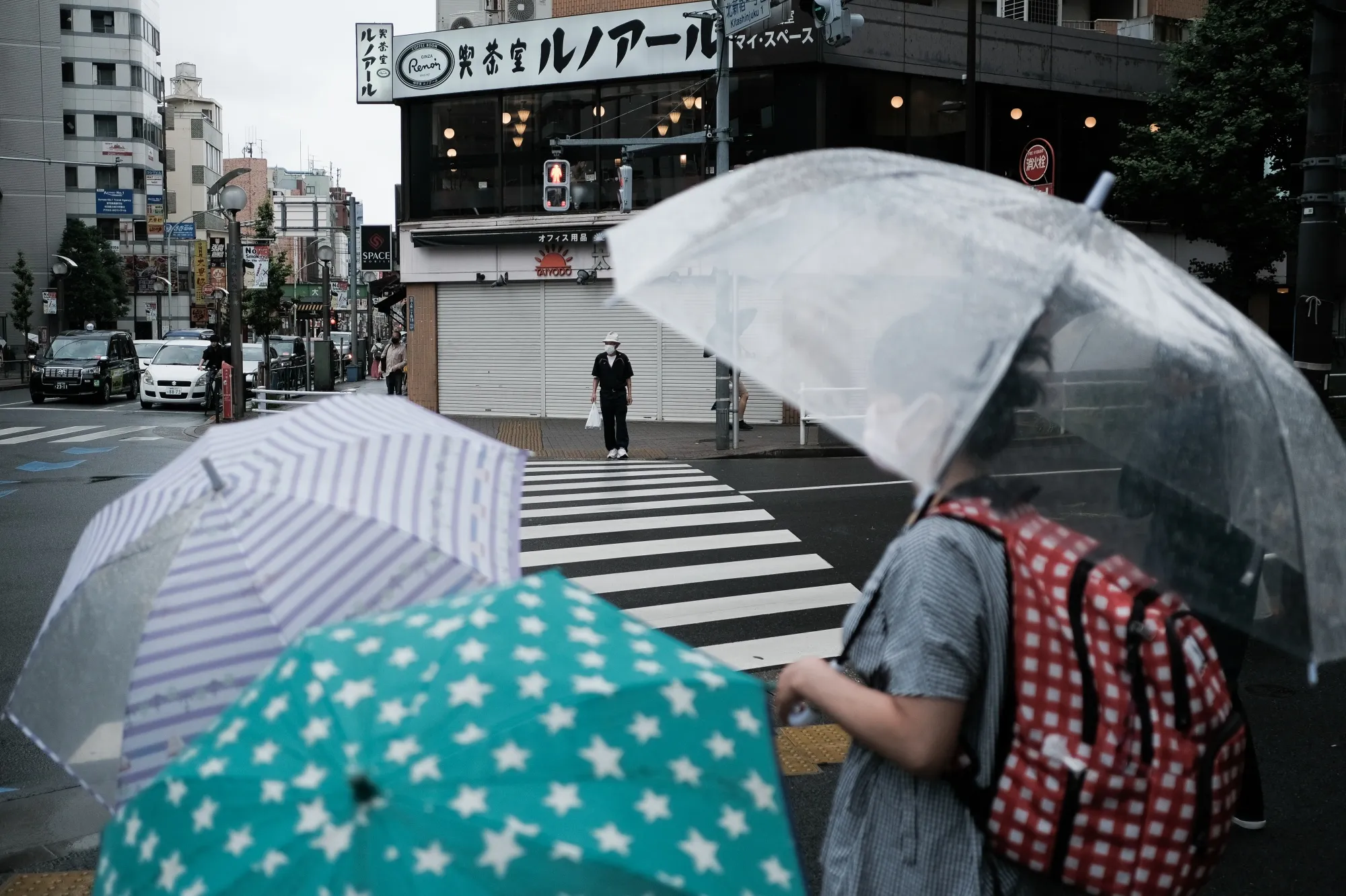 People&nbsp;wait&nbsp;to cross a street in the Shinjuku district of Tokyo on June 14.