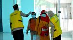 Health officials check the body temperature of passengers at the Mutiara SIS Al Jufri airport in Palu, Central Sulawesi on Jan. 29.