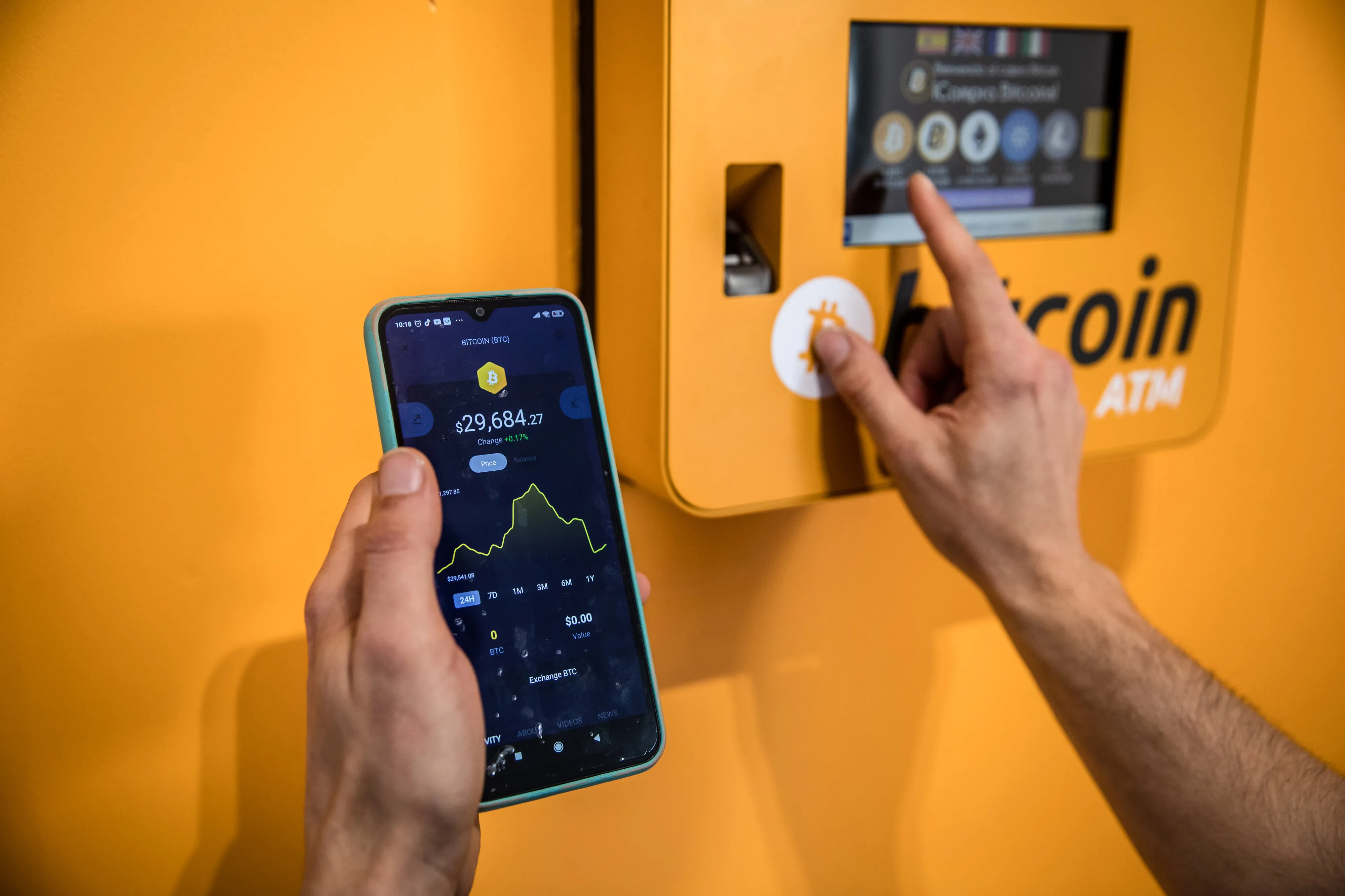 A customer inspects a Bitcoin price chart at a cryptocurrency ATM&nbsp;in Barcelona, Spain.