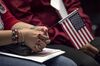 An applicant for U.S. citizenship holds an American flag during a naturalization ceremony at the Evo A. DeConcini U.S. Courthouse in Tucson, Arizona, U.S., on Friday, Sept. 16, 2016. From October 2015 through June 2016, 718,000 legal permanent residents applied for citizenship, up 8 percent compared to the same period leading up to the 2012 presidential election, according to federal data.