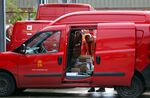 An employee places parcels for delivery into a van at the Royal Mail Plc sorting office in Chelmsford, UK.