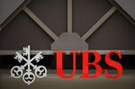 A logo sits on display above the entrance to a UBS Group AG bank branch in Munchenbuchsee, Switzerland.