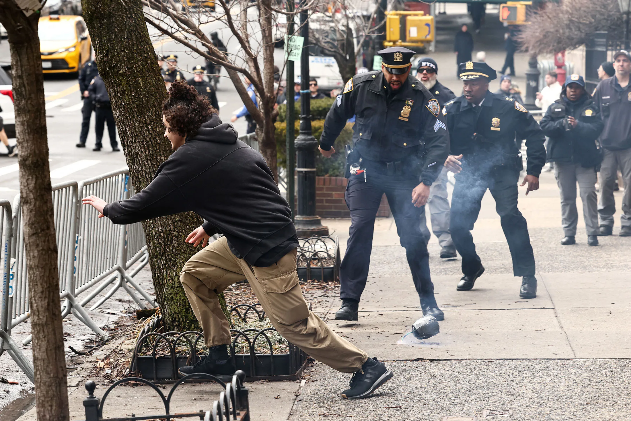 A counter-protester flees after throwing a homemade explosive device towards police during a protest organized by far-right influencer Jake Lang in front of Gracie Mansion in New York on March 7.