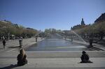 Pedestrians sit by the fountains at the Kungstradgarden park in Stockholm on April 23.