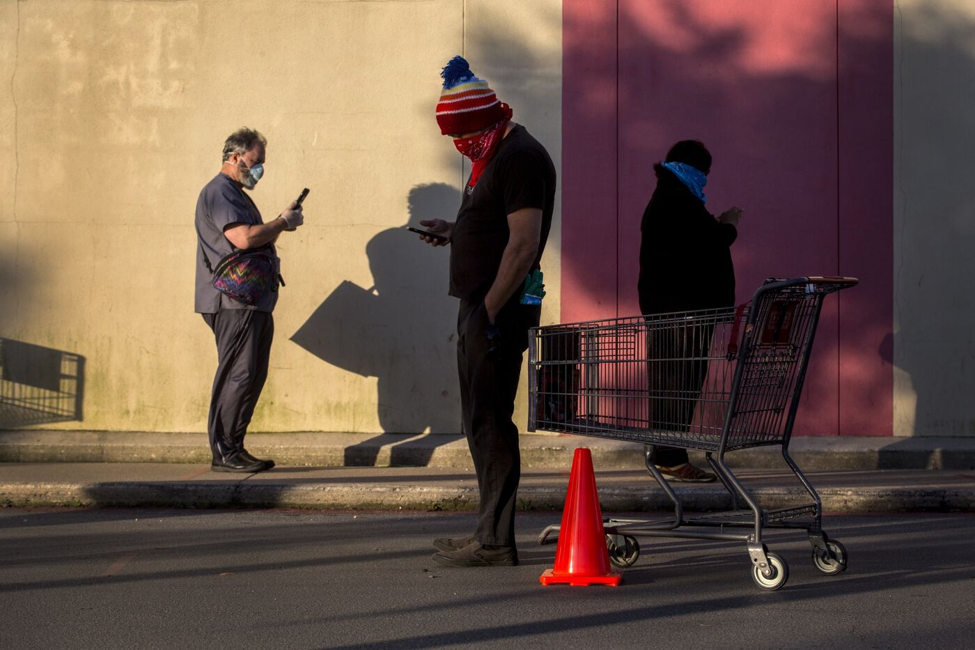 Customers wearing protective masks and gloves stand in line outside a grocery store in Austin, Texas, on April 13. Customers wearing protective masks and gloves stand in line outside a grocery store in Austin, Texas, on April 13.