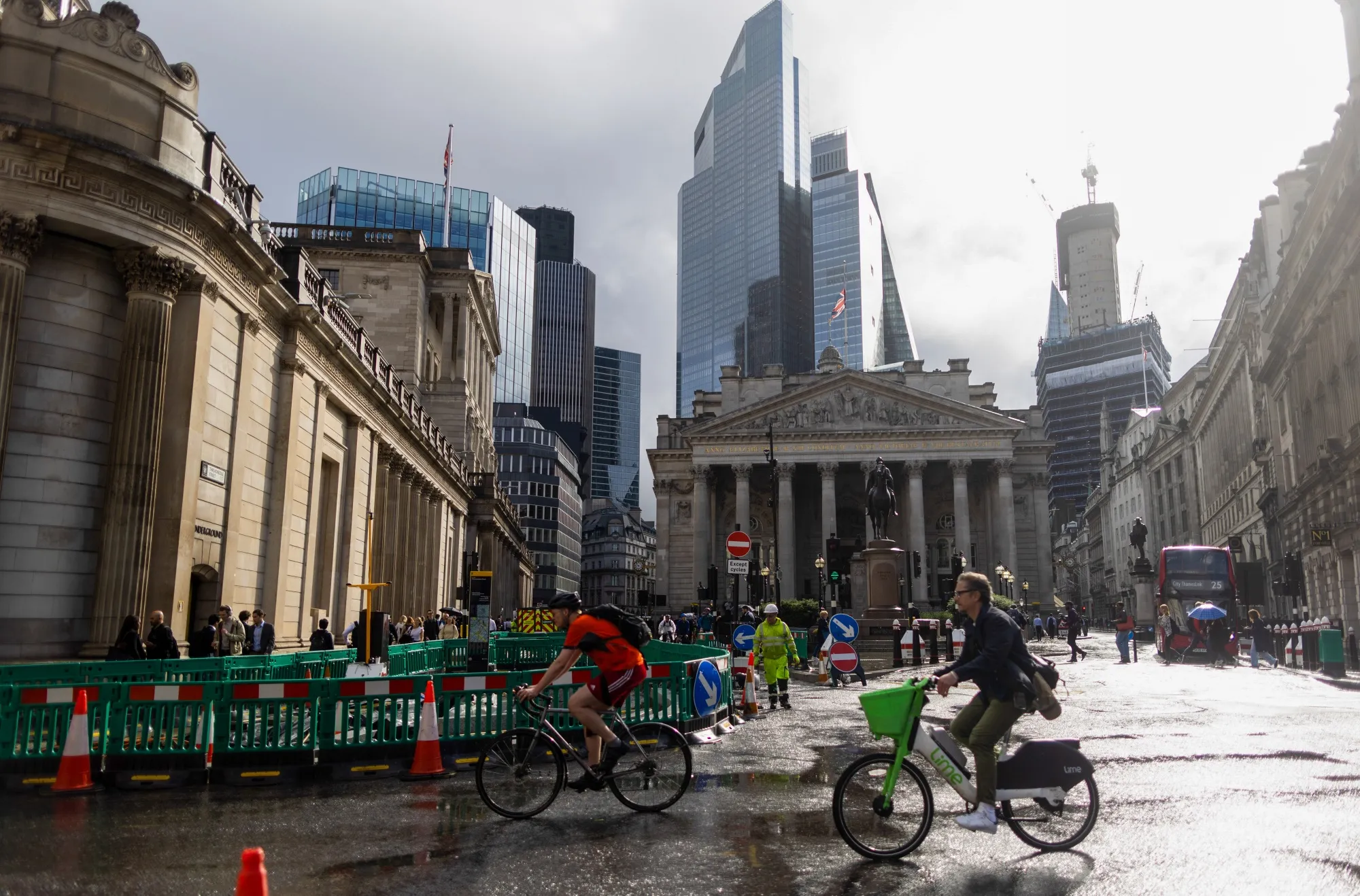 Commuters pass the Bank of England (BOE), left, in the City of London.