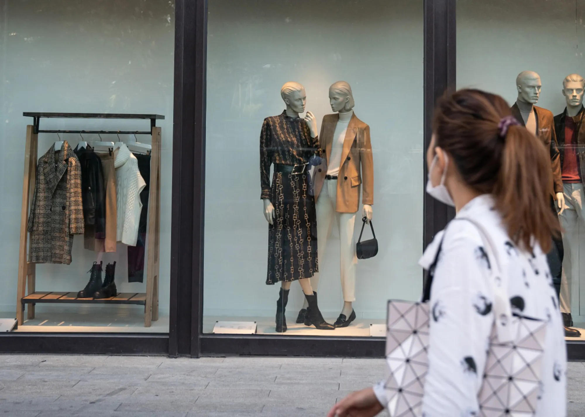 Pedestrians walk past a store in Beijing.