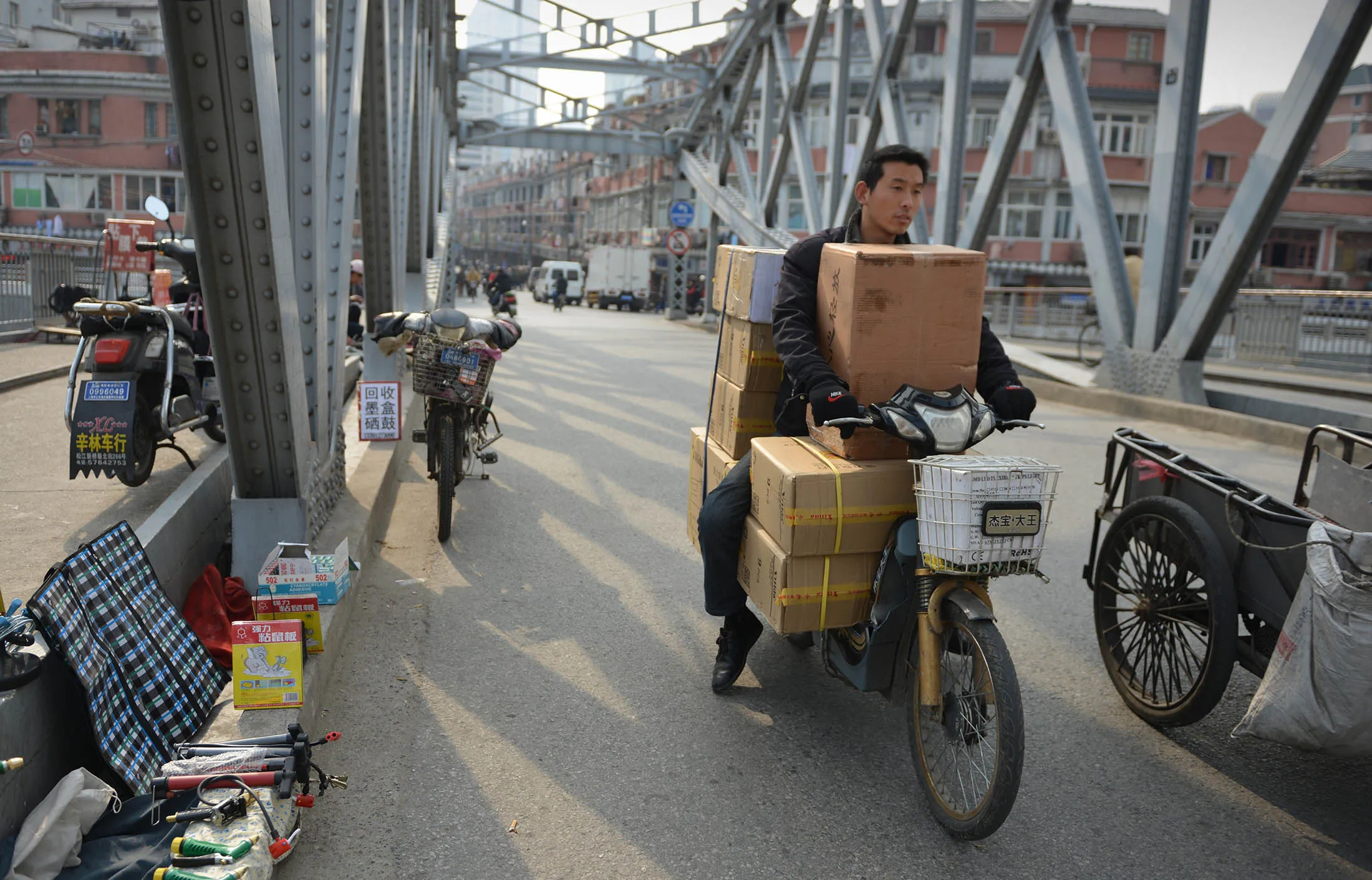 A motorcyclist carries goods over a bridge in Shanghai.
