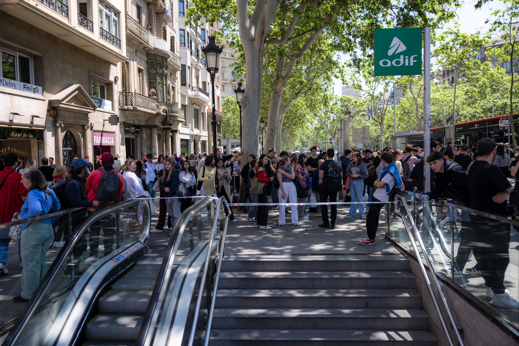 Pedestrians gathered outside a train station closed due to a power outage in Barcelona, Spain, on Monday, April 28, 2025.
