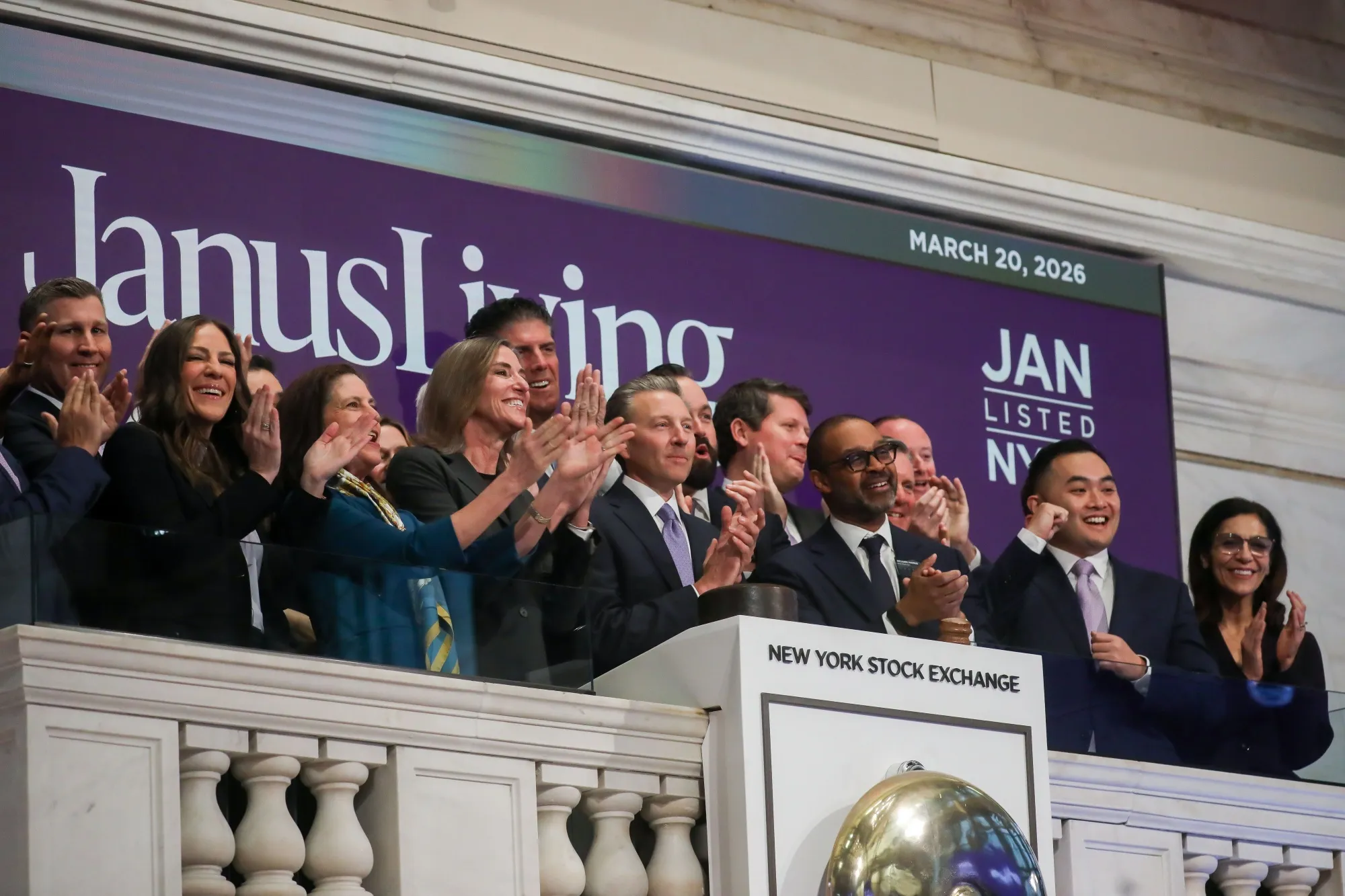 Scott Brinker, president and chief executive officer of Janus Living Inc., center, rings the opening bell during the company's IPO at the New York Stock Exchange on March 20.