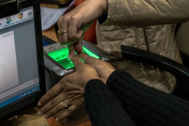 A worker operates a thumbprint scanner at a registration center for India's Aadhaar identification card program, in New Delhi, Feb. 15, 2018.