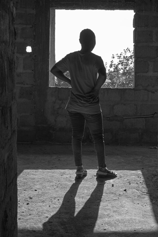 Black and white portrait of "Rebecca" facing a window, who works as a tapper at the Liberian Agricultural Co. plantation owned by Socfin. <br> <br> She and other women at the rubber plantation say they face continual demands for sex from supervisors.