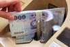 A clerk counts Taiwan 1000 dollar notes