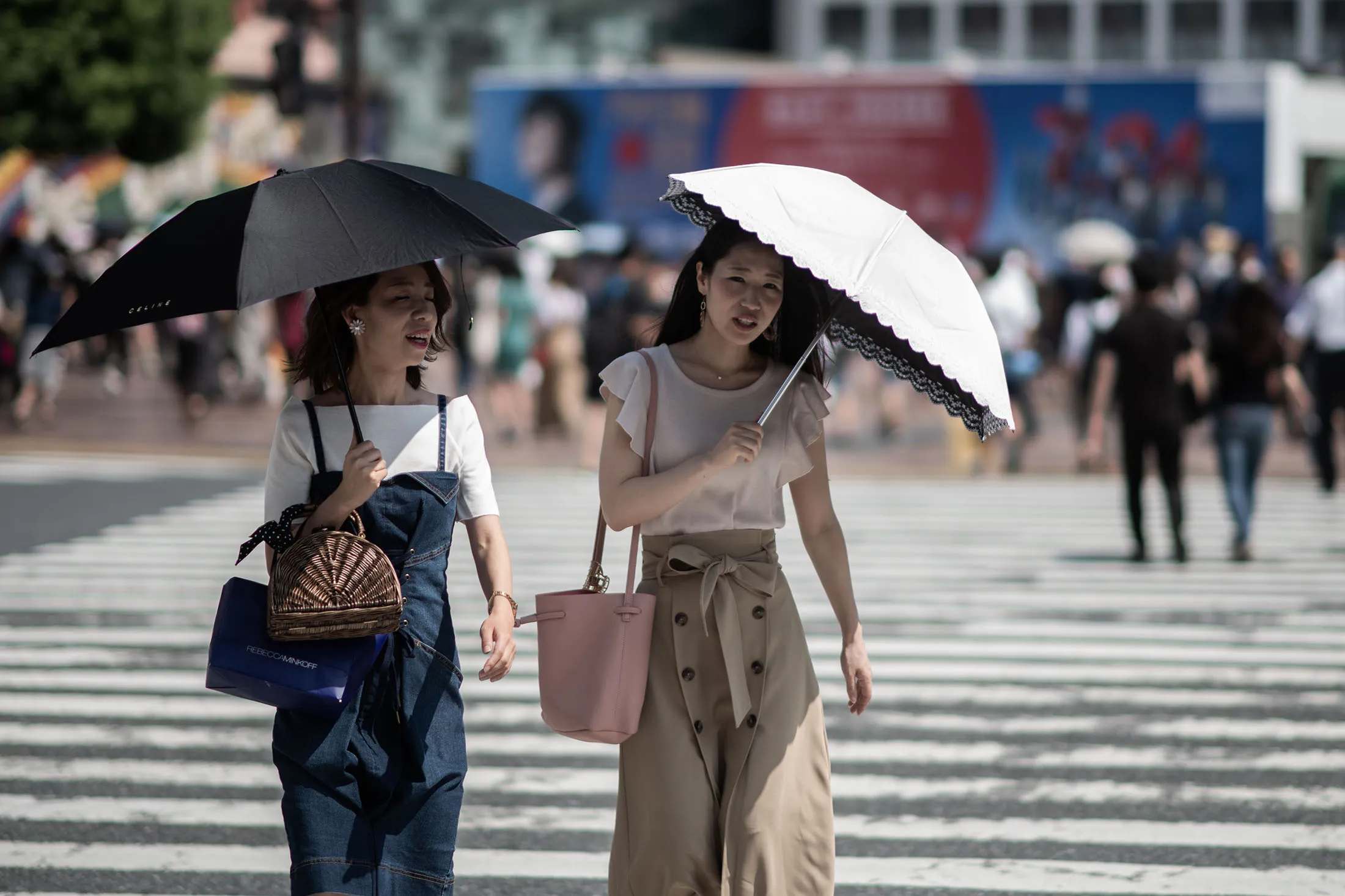 Women shield themselves from the sun with umbrellas in Tokyo on July 24.