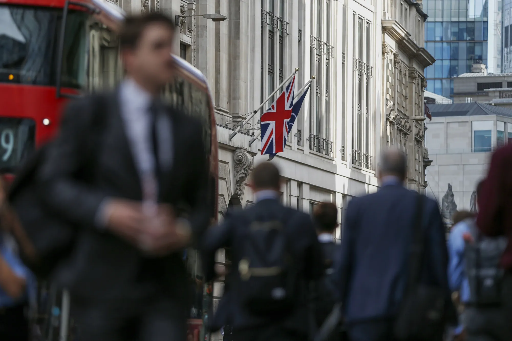 Commuters walk through the City of London financial district.