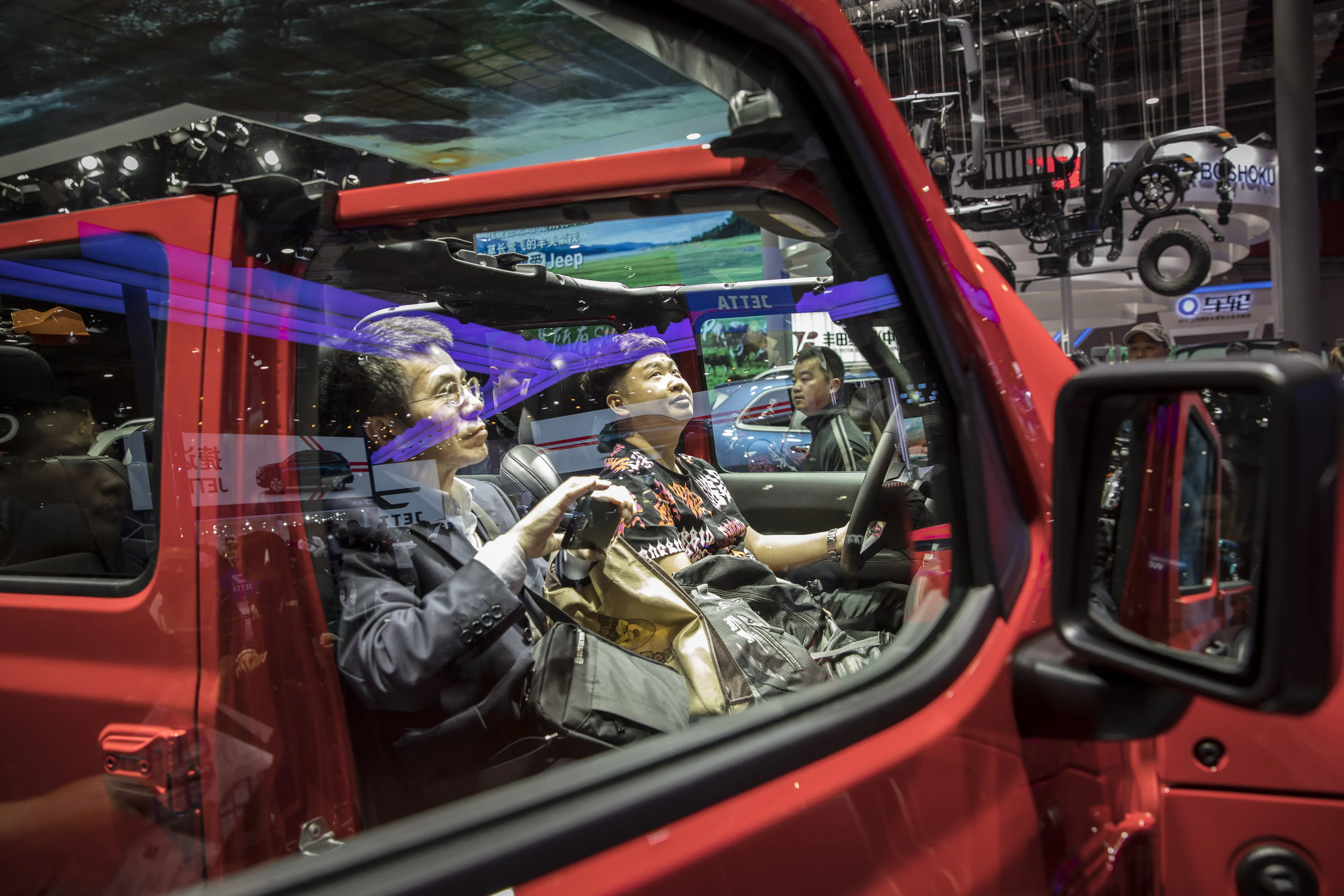 Attendees sit in Jeep Wrangler Rubicon the Auto Shanghai 2019.
