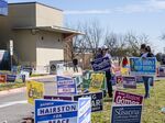Election advocates hold campaign signs outside a polling location during primary elections in Austin, Texas, on March 1.