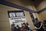 A "Now Hiring!" sign stands on display next to the Jiffy Lube International Inc. booth during a Job News USA career fair in Overland Park, Kansas, U.S., on Wednesday, March 8, 2017. 