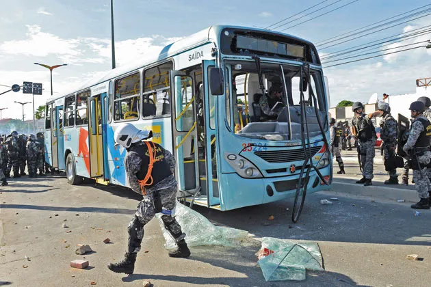 Police defend a bus attacked by Brazilian demonstrators