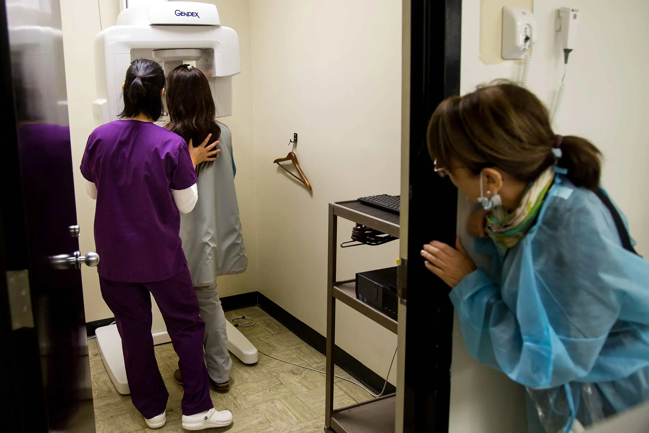 A dental hygiene student prepares a patient for a panoramic X-ray, as her assistant professor looks on, in Brooklyn, N.Y.
