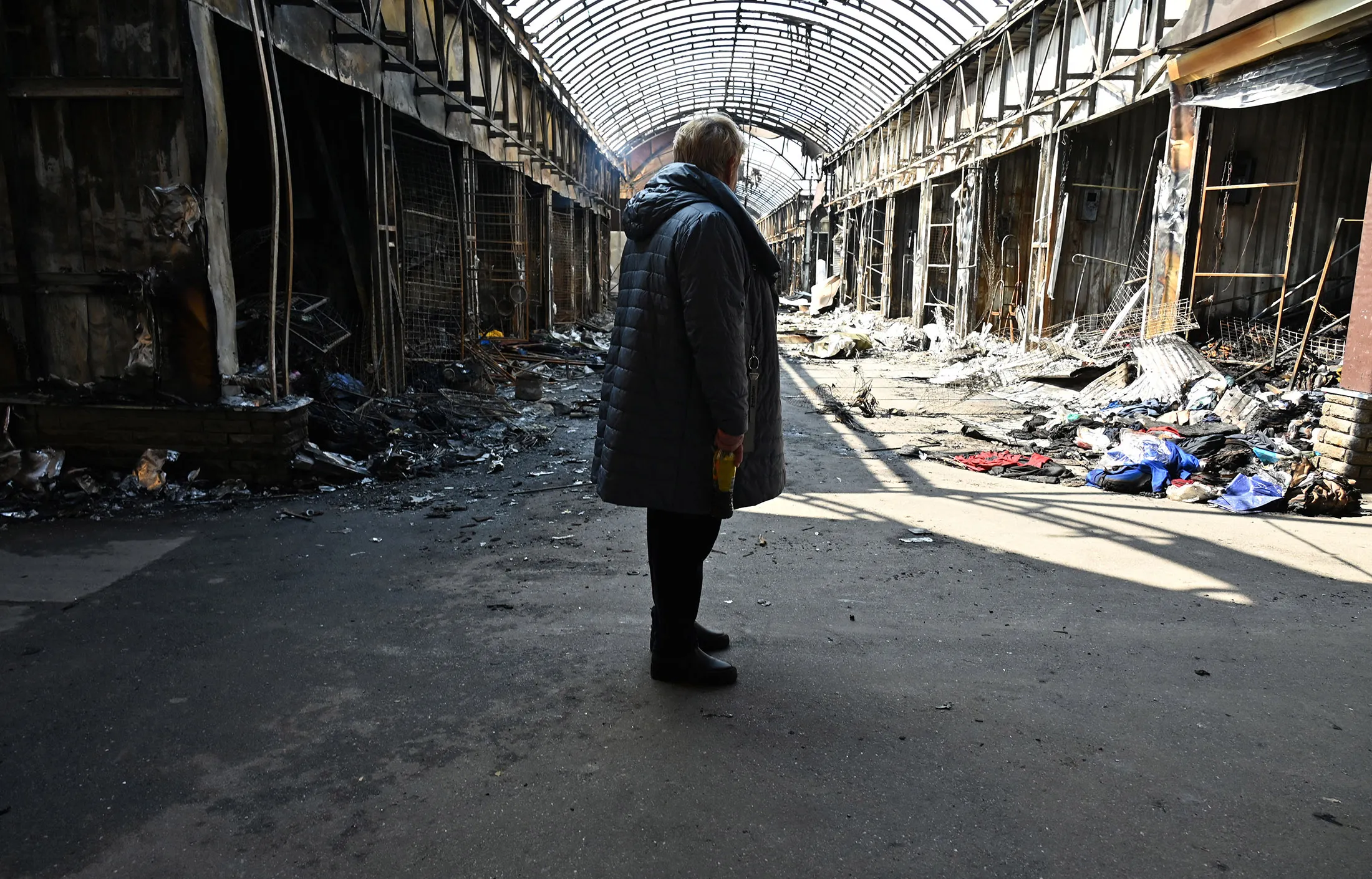 A resident stands between damaged stores at a local market after recent shelling in the northern outskirts of Kharkiv, on April 21.
