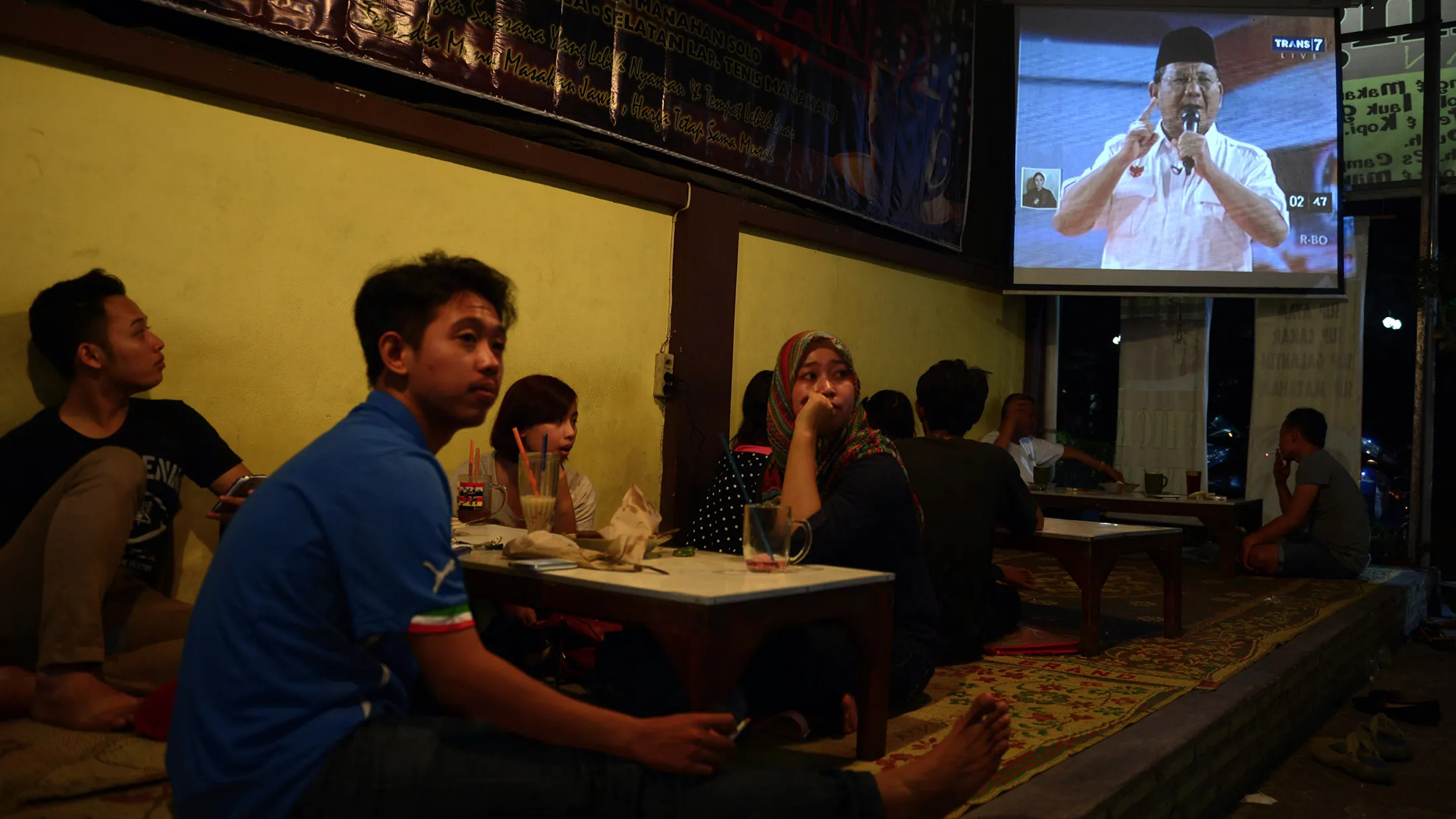 In this photograph taken on June 15, 2014, customers at a restaurant watch the live broadcast of the one on one debate between Indonesian presidential candidates Prabowo Subianto (seen on television screen) with opponent Joko Widodo in Solo city, the hometown of Widodo located in central Java island. Campaigning for Indonesia's July presidential election officially kicked off on June 4, with favourite Joko Widodo facing a tough challenge from a Suharto-era former general with a chequered human rights record. AFP PHOTO / ROMEO GACAD (Photo credit should read ROMEO GACAD/AFP/Getty Images)
