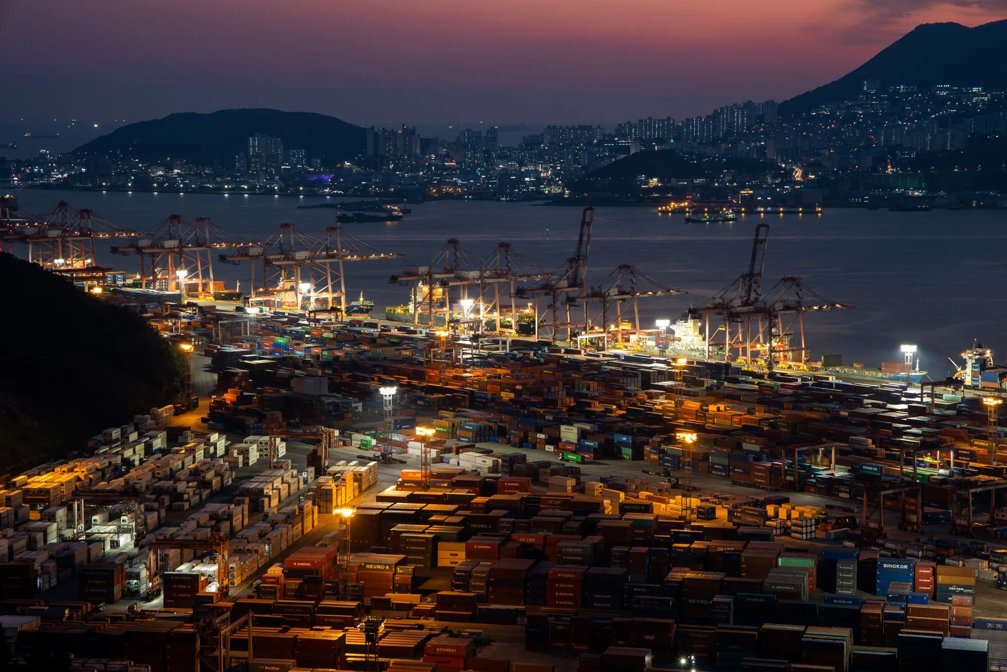 Shipping containers sit among gantry cranes in the Busan Port Terminal in South Korea.